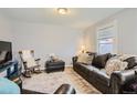 Comfortable living room with a leather sofa, rocking chair, and soft lighting at 1629 Valentia St, Denver, CO 80220