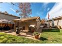 The backyard of this home features a patio with umbrella-covered seating and mature landscaping at 9310 Pierce St, Broomfield, CO 80021