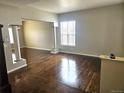 Spacious living room area with rich wood flooring, natural light and decorative columns at 21580 Longs Peak Ln, Parker, CO 80138