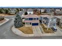 Inviting two-story home boasts a blue exterior, a spacious driveway, and a well-maintained lawn at 4539 Lyndenwood Cir, Highlands Ranch, CO 80130