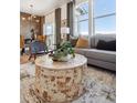 Cozy living area with natural light, comfortable seating, and a decorative, round wood table at 924 Andrews Crest Dr, Berthoud, CO 80513