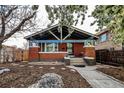 Charming brick home featuring a landscaped front yard, stone walkway, and flowering trees at 241 N Grant St, Denver, CO 80203