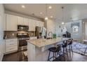 Bright kitchen showcasing an island with barstool seating and pendant lighting at 15530 W 64Th Pl # C, Arvada, CO 80007