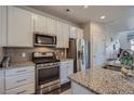 Modern kitchen featuring granite countertops, stainless steel appliances and white cabinetry at 15530 W 64Th Pl # C, Arvada, CO 80007