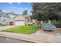 Beautiful brick home with mature landscaping and lush green lawn at 11237 W Ford Dr, Lakewood, CO 80226