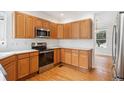 Kitchen featuring stainless steel appliances, light wood cabinets and hardwood floors at 11237 W Ford Dr, Lakewood, CO 80226