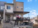 A modern multi-story townhome showcases a spacious covered balcony, attractive stone accents, and manicured landscaping at 1039 Leonard Ln, Louisville, CO 80027