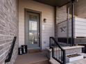 Inviting front entrance featuring a modern gray door, brick accents, and decorative outdoor lighting at 1039 Leonard Ln, Louisville, CO 80027