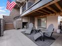 Relaxing outdoor patio with comfortable seating, an outdoor fireplace, and a view of the underside of the home's deck at 1039 Leonard Ln, Louisville, CO 80027