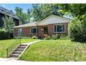 Traditional brick home with a well-kept lawn, front garden, and inviting walkway to the front door at 2635 Julian St, Denver, CO 80211