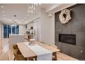 Dining area showcasing fireplace, modern lighting, wood floors, and access to the kitchen with an island at 3232 W 16 Ave, Denver, CO 80204