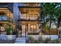Modern three-story home featuring multiple balconies and sleek design with a gated front yard and modern lighting at 3232 W 16 Ave, Denver, CO 80204