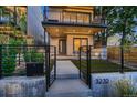 Contemporary home exterior with a well-manicured front yard, gated entry, and modern architectural details at 3232 W 16 Ave, Denver, CO 80204