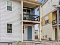 Stylish townhome entrance with a covered balcony, bright blue door, and manicured gravel landscaping at 6162 W 28Th Ct, Wheat Ridge, CO 80214