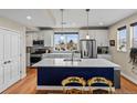Bright, open kitchen with a large island, stainless steel appliances, and modern white cabinets at 6162 W 28Th Ct, Wheat Ridge, CO 80214