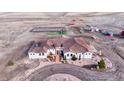 Expansive property featuring a custom home, outbuildings, fenced area, and picturesque landscape at 7172 S Oakleaf St, Bennett, CO 80102