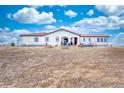 The back exterior features a covered patio, picnic tables, and an open yard at 7172 S Oakleaf St, Bennett, CO 80102