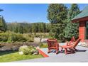 A cozy outdoor deck features wooden chairs, a small table, and a stunning mountain view at 189 Ginger Quill Ln, Breckenridge, CO 80424
