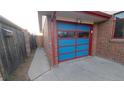 A single car garage featuring a distinctive, brightly painted door at 1977 S Yates S St, Denver, CO 80219