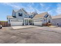 Impressive two-story home boasts a three-car garage, a neutral gray exterior, and a vast paved driveway at 3434 Antelope Ridge Trl, Parker, CO 80138