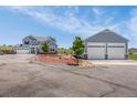 Sprawling property featuring a well-maintained home and detached garage, set against a lush green backdrop at 3434 Antelope Ridge Trl, Parker, CO 80138