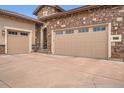 Spacious three-car garage with a charming brick exterior and a well-manicured driveway at 10646 Winding Pine Pt, Highlands Ranch, CO 80126