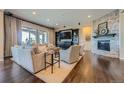 Bright living room boasting hardwood floors, a stone fireplace, and large windows for natural light at 10646 Winding Pine Pt, Highlands Ranch, CO 80126