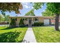 Well-manicured lawn and landscaping highlight this charming brick home, complete with an attached garage at 12162 W Dakota Dr, Lakewood, CO 80228