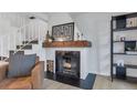 Close up of a modern fireplace with a wooden mantle, adding warmth and character to the living space at 9424 E Girard Ave, Denver, CO 80231