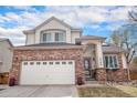 Charming two-story home featuring a brick facade, a two-car garage, and a well-maintained front yard under a beautiful sky at 3764 Balderas St, Brighton, CO 80601