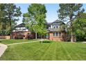 Beautiful two-story home with a lush lawn, mature trees, and classic Tudor architectural details at 5441 S Dayton Ct, Greenwood Village, CO 80111