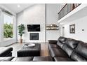 Open living room features a brick fireplace, large windows, and access to the second story landing at 5441 S Dayton Ct, Greenwood Village, CO 80111