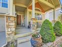 Close-up of the front entrance showcasing stone pillars, a wooden front door, and a decorative front porch at 301 Harvest St, Longmont, CO 80501
