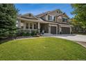 Charming two-story home showcasing a covered porch, well-manicured lawn, and a three-car garage at 4848 Wagontrail Ct, Parker, CO 80134