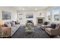 Bright and airy living room with neutral tones, fireplace, stylish furniture, and a decorative area rug at 594 Fall River Ct, Brighton, CO 80601