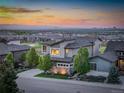 Aerial view of a modern home with a well-manicured lawn and a view of the cityscape at sunset at 9441 Night Star Pl, Lone Tree, CO 80124