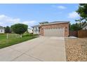 Inviting single-story home with brick accents, a two-car garage, and a concrete driveway at 11847 Trail View Ln, Parker, CO 80134