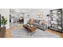 Comfortable living room featuring a gray sofa, stylish rug, and open layout to the kitchen and dining area at 757 S Wheeling St, Aurora, CO 80012