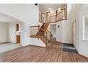Open foyer with hardwood floors, a staircase, and views to other rooms at 11642 Moline Ct, Commerce City, CO 80640