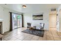 Living room showcasing tile floors, sliding glass doors to a balcony, and neutral decor at 10251 W 44Th Ave # 8-102, Wheat Ridge, CO 80033