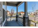 View from the covered porch showcasing stone pillars and a glimpse of the neighborhood at 20936 E 61St Ave, Aurora, CO 80019