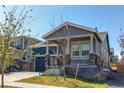 Inviting two-story home featuring a cozy covered porch, a well-kept lawn, and a two-car garage at 20936 E 61St Ave, Aurora, CO 80019