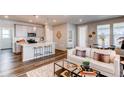 Open-concept living space with modern finishes, hardwood floors, and a kitchen island with seating at 20936 E 61St Ave, Aurora, CO 80019