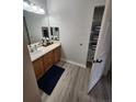 Bathroom features wood vanity, framed mirror, and linen closet for extra storage at 5755 N Genoa Way # 14-105, Aurora, CO 80019