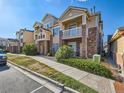 Attractive multi-story townhome features private balconies, brick accents, and well-maintained landscaping at 5755 N Genoa Way # 14-105, Aurora, CO 80019