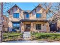 Elegant brick home featuring a welcoming front porch, a beautifully landscaped yard, and meticulous architectural details at 457 S Vine St, Denver, CO 80209