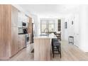Spacious kitchen featuring modern cabinetry, a large island, stainless steel appliances and hardwood floors at 879 Delaware St, Denver, CO 80204