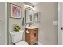 Compact bathroom with a wooden vanity, modern mirror, and tasteful decor at 1820 Newland Ct # 201, Lakewood, CO 80214