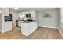 Bright kitchen featuring white cabinets, stainless steel appliances, and hardwood floors at 1820 Newland Ct # 201, Lakewood, CO 80214