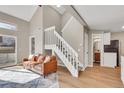 Open-concept living room showcasing hardwood floors, a staircase, and access to the kitchen and other areas at 1820 Newland Ct # 201, Lakewood, CO 80214